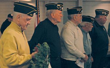 Members of American Legion Post 370 wait their turn to place memorial wreaths in honor of each branch of the United States military.