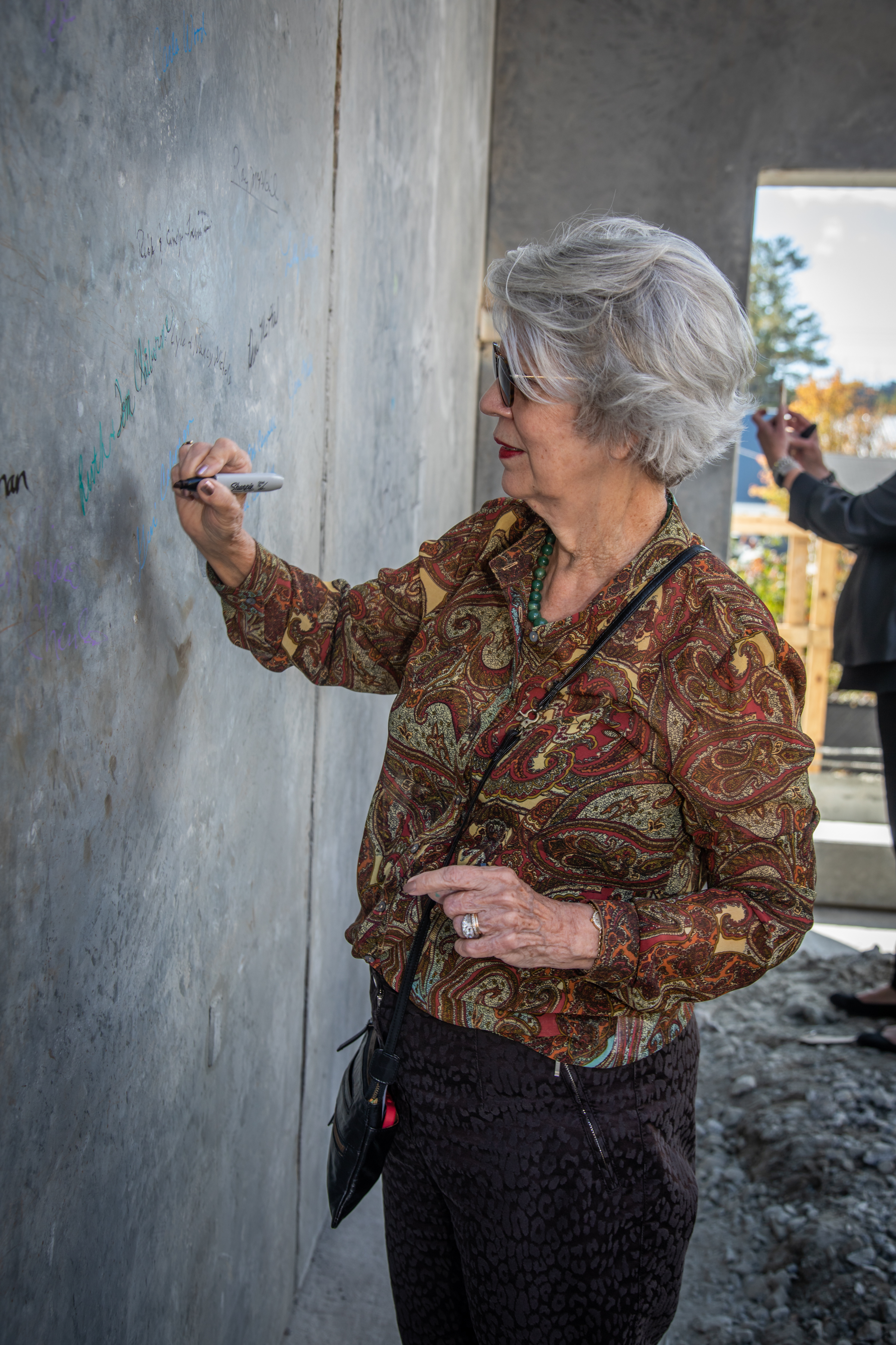 Ruth Clairborne, PAC vice president, signs the wall.