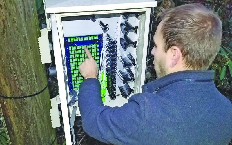 Highlands Cable Group network engineer Rick Yinger connects fiber lines to a port system in the Holt Knob neighborhood.
