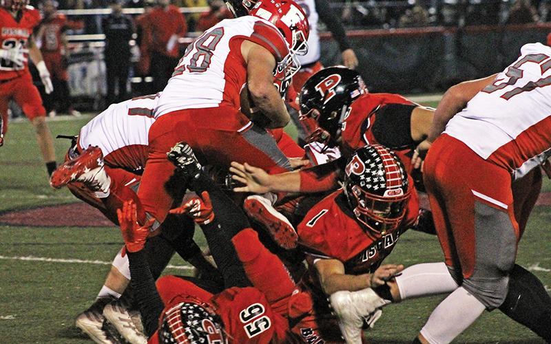 Press photo/Andy Scheidler - Franklin junior Seth Price leaps over a pile of players during last week’s game at Pisgah. It was the junior’s first game action since he broke his collarbone in September.