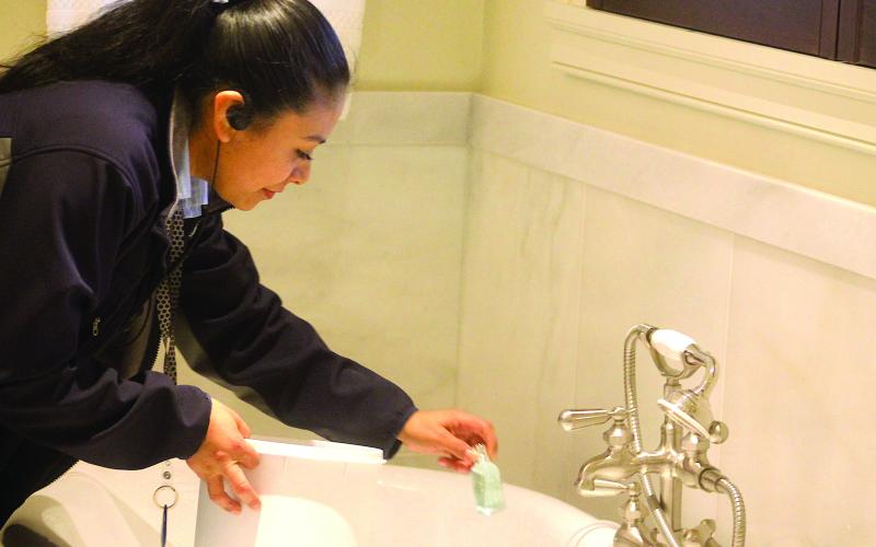 Sandra Valero, housekeeping supervisor with Old Edwards Inn separates single-use plastic shampoo and conditioner bottles for recycling.