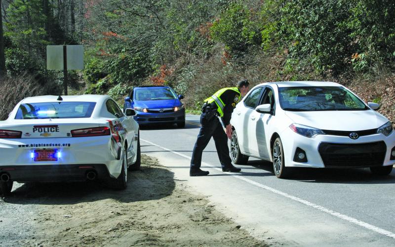 Highlands Police Department officer Tim Broughton stops drivers at a checkpoint along US 64 on Friday. The state of North Carolina is now under a “Stay at home” order and both Macon County and the Town of Highlands are urging residents to comply.