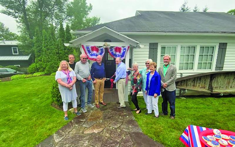 Highlands Historical Society president Obie Oakley cuts the ribbon surrounded by board members and Highlands mayor Patrick Taylor.