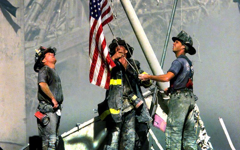 Submitted Photo Firefighters lifting the American Flag during 9/11.