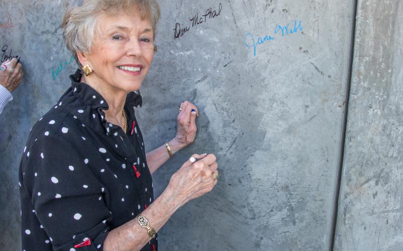 Jane Webb, PAC secretary, signs the wall.