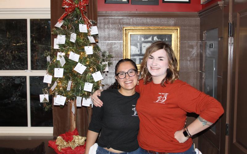 Photo by Christopher Smith/Staff Ugly Dog Pub manager Kellye Vos with worker Aileen Enriquez in front of the Christmas Tree.