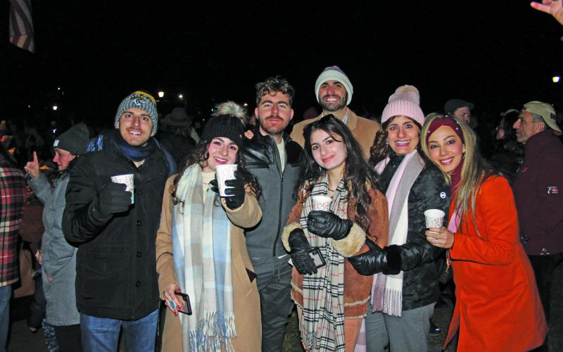 A group enjoys hot chocolate at the tree lighting.