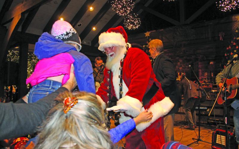 Santa Claus greeting children.