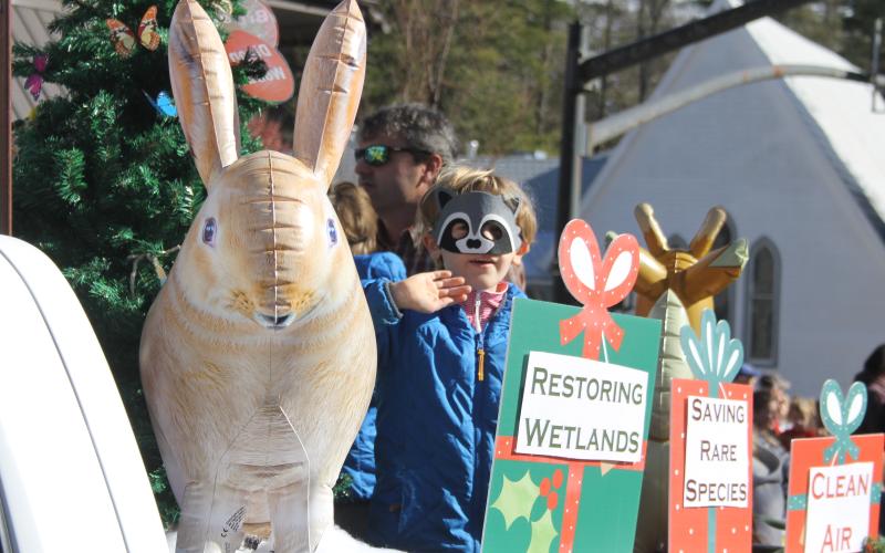 Photo by Christopher Lugo/Staff A child waving during the parade from a float.