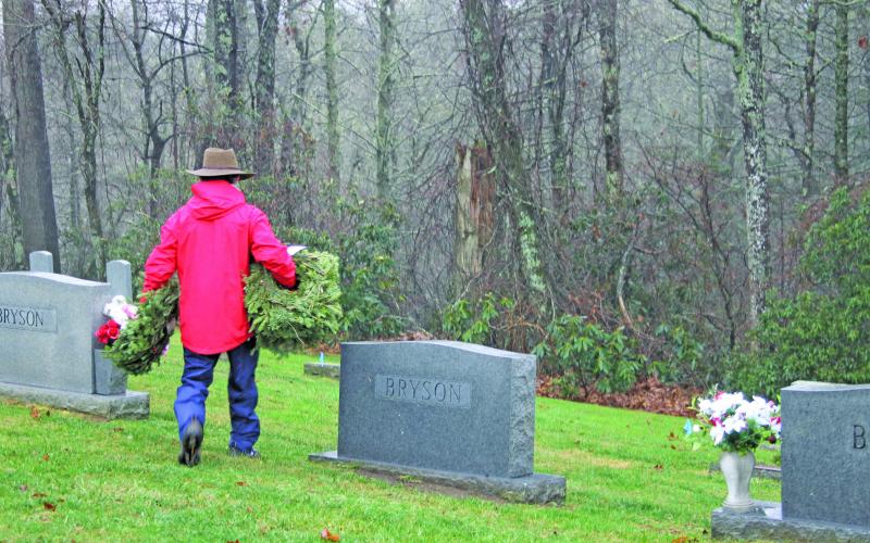 Photo by Christopher Lugo/Staff A volunteer takes wreaths to be placed on veterans’ headstones.
