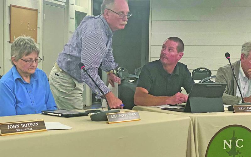 Commissioner Buz Dotson talks with Commissioner Eric Pierson during their meeting last Thursday night.