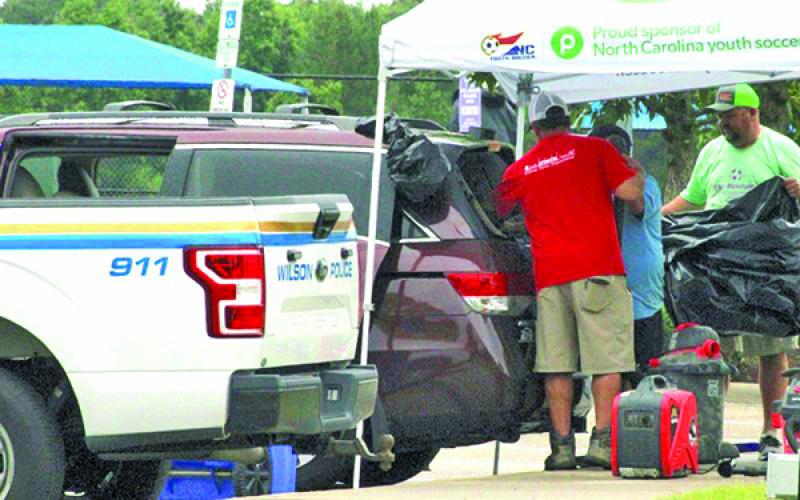 Photo by The Wilson Times A Honda Odyssey van is vacuumed after gunfire shattered its back window at the Gillette Athletic Complex in Wilson, NC.