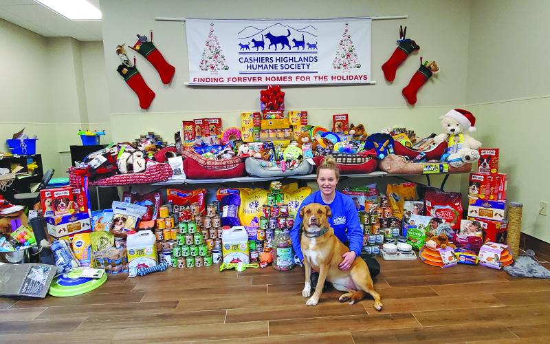 CHHS assistant manager Jodi Henkel plays with one of the shelter’s resident pups in front of the “Stuff the Stockings” donation table. Donations will ensure that the animals at CHHS have a merry Christmas.