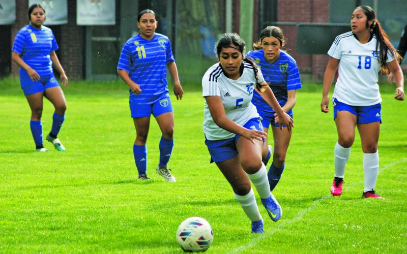 Highlands’ Aislynn Wyatt-Luck chases down Elkins midfielder Jade Bravo (5) during their NC High School Athletic Association 1-A State Playoff game on Monday night.