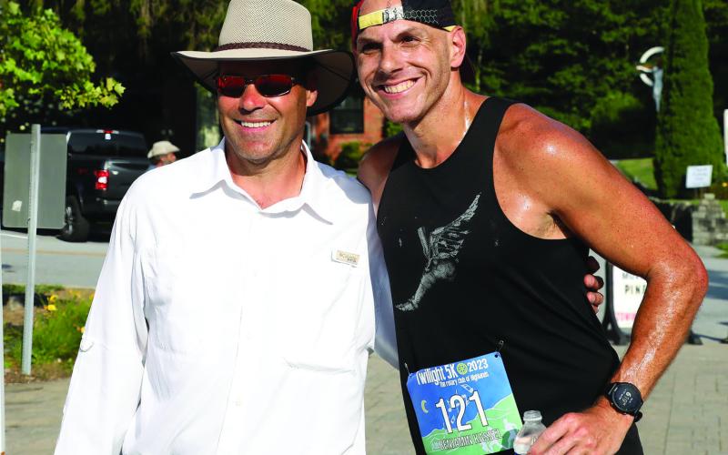 Highlands Twilight 5k organizer Derek Taylor greets race winner Ben Kassel, of Davidson, North Carolina, who set a new course record on Saturday night.