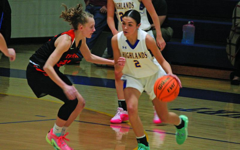 Highlands’ Aislynn Wyatt-Luck (2) tries to drive around a Rosman defender on Friday.