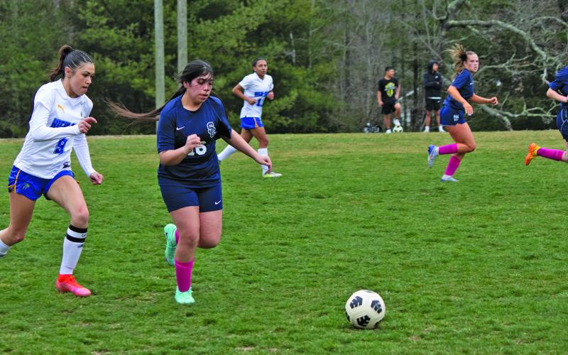 Highlands’ Aislynn Wyatt-Luck (9) chases down a Summit Charter midfielder during their season-opening soccer match on Tuesday night.