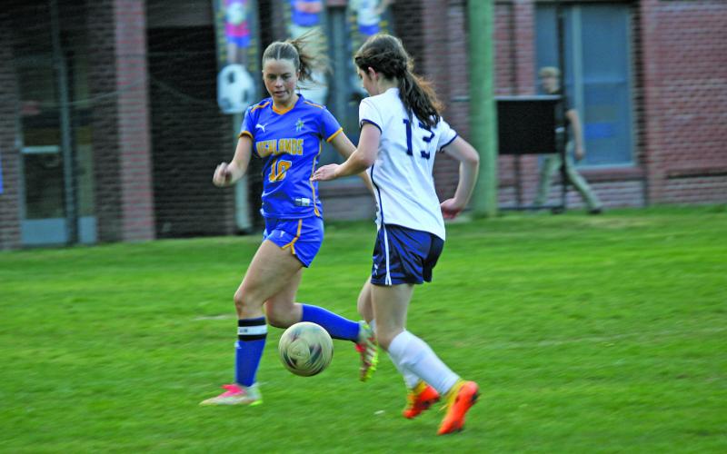 At the home game Thursday, April 18, Senior Mackenzie Woods runs to intercept the ball before an opponent.