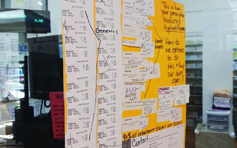 Sherry Sims hung up several receipts she’s gotten from insurance companies, which she said shows the poor reimbursement rates on prescriptions that might force her to close her business if she keeps losing money.