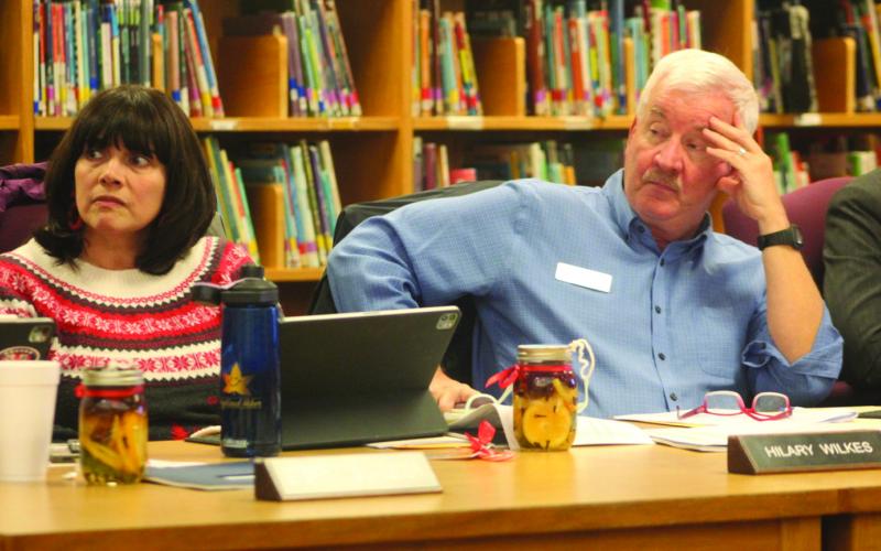 Macon County School Board members Jim Breedlove and Hilary Wilkes listen to a presentation regarding an issue with the heating system at Highlands School.