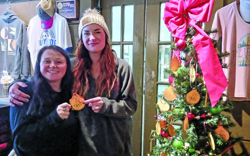 Ugly Dog Public House manager Kellye Wert (right) and server Charity Barnes at the restaurant, which is a site where people can donate gifts for the Angel Tree program.