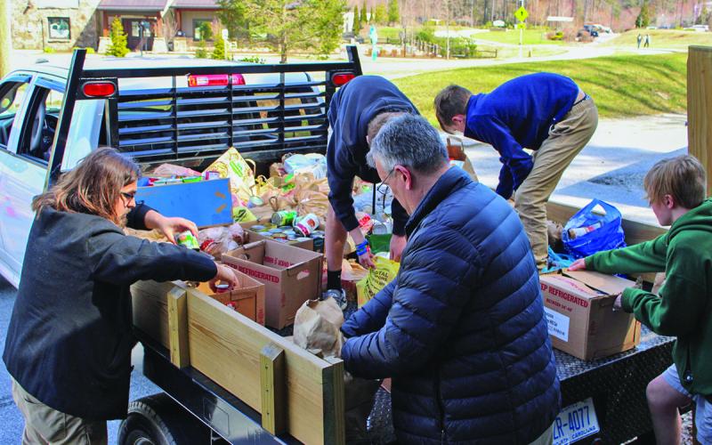 Volunteers with Fishes and Loaves Food Pantry in Cashiers unload a truck filled with donated items following Hurricane Helene.