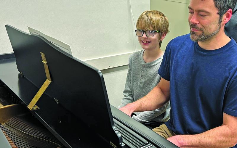 JCYC accompanist Bryan Heller gives chorus member Riley Breedlove a preview of a song he will sing when rehearsals begin in March.