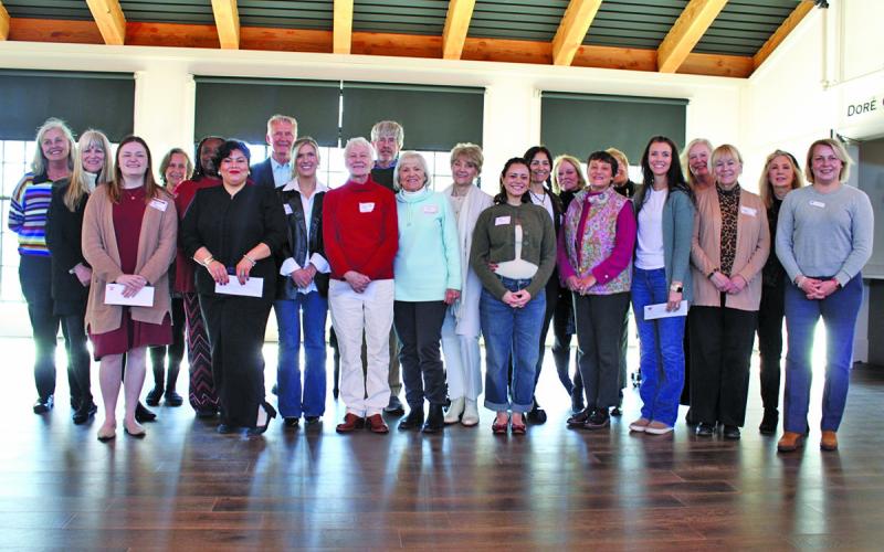 Members of Cashiers Cares gathered on the stage at The Village Green prior to a grant award ceremony last week.