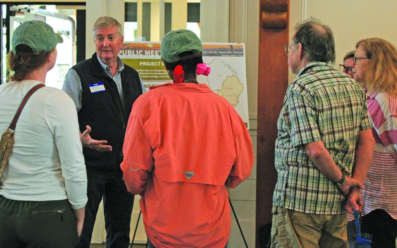 Headwaters District Conservation Plan steering committee member David Feist, who represents the Friends of Lake Glenville, discusses the proposed plan and the methodology behind it with a group of citizens at The Village Green in Cashiers on Wednesday.