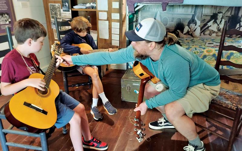 Instructor Will Starns teaching guitar at Colonel John’s Cabin.