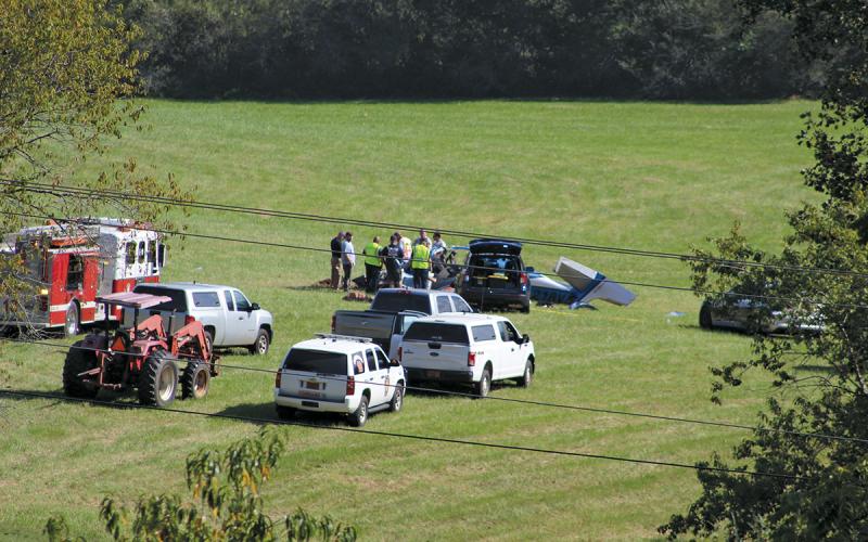 Emergency personnel respond to a plane crash Thursday afternoon in a field west of Iotla Valley Elementary School. The three people aboard will killed.