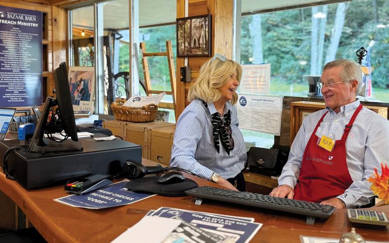 Volunteer Ray MaGaro talks with assistant sales manager Cathy Maddock at The Bazaar Barn on Saturday morning.