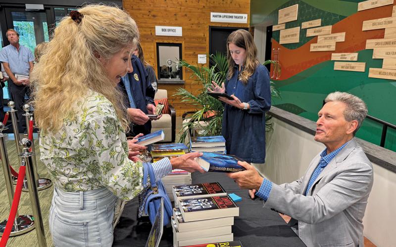 Author David Baldacci signs a copy of his newest book “Strangers in Time” for Becky Harris of Highlands. Baldacci was the guest speaker for the Literacy and Learning Center’s annual “Celebration of Education” fundraiser on Sept. 30. The event included a talk with the author Thursday afternoon at the Performing Arts Center and a VIP Patron Dinner that evening at Old Edwards Club.