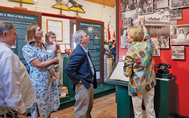 Visitors at the Cashiers Historical Society observe photos and learn about the history of High Hampton Inn at the “Let No One Be a Stranger Here”: High Hampton Inn &amp; the Making of Modern Cashiers exhibit.  |  Photo courtesy of Cashiers Historical Society