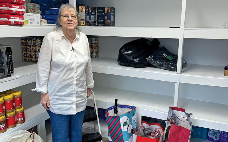 Lead volunteer Marie Johnson poses with donated gifts from the Angel Trees gift-giving program at the Highlands Emergency Council on Dec. 17.