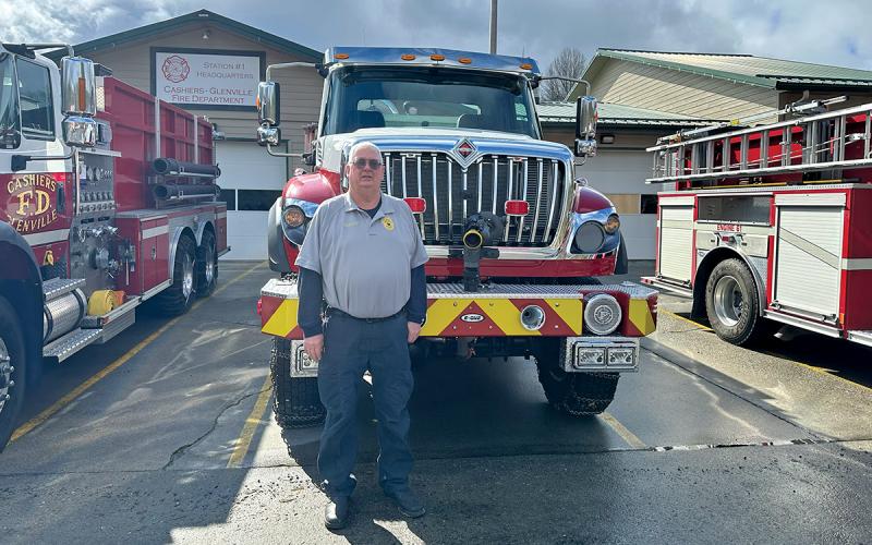 Chief Dillard poses with the four-wheel drive, full-size E-One pumper at Cashiers-Glenville Fire Department Station 1.