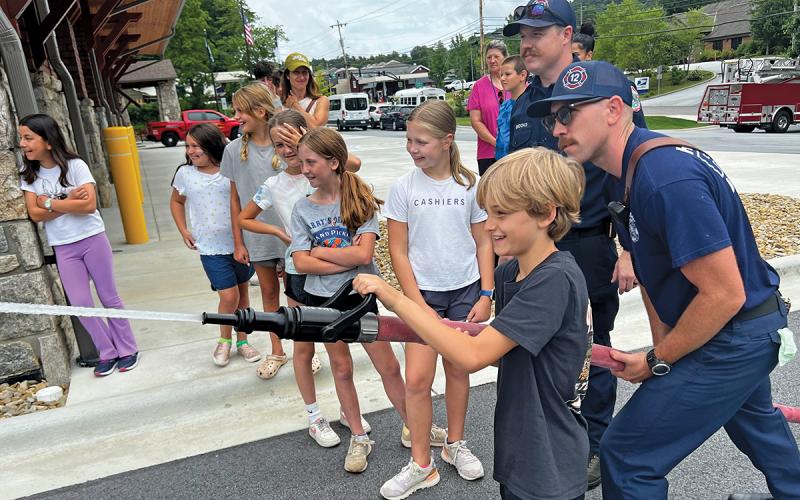 The Cashiers-Glenville Fire Department teaches “Littles” how to use fire equipment during a fun day with BBBS.  |  Photo by Danielle Hernandez