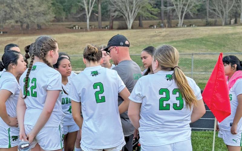 BREC Head Coach Nickalus Pressler discusses tactics with his team at halftime during their match against MEC. The Lady Bobcats drew 1-1.  |  Photo courtesy of BREC
