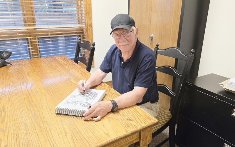 Duncan Greenlee works on the cartoon for the July 16 edition of The Highlander. Greenlee has been drawing for paper since 1986.