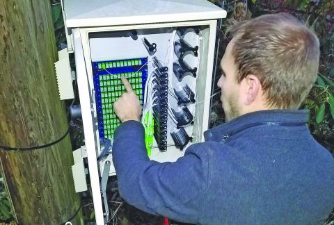 Highlands Cable Group network engineer Rick Yinger connects fiber lines to a port system in the Holt Knob neighborhood.