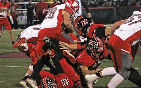 Press photo/Andy Scheidler - Franklin junior Seth Price leaps over a pile of players during last week’s game at Pisgah. It was the junior’s first game action since he broke his collarbone in September. 