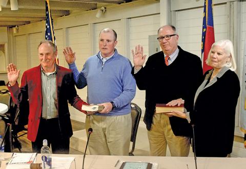 John “Buz” Dotson, Brian Stiehler and Marc Hehn, with the family Bible held by his wife Betsy, are sworn in as commissioners during the Dec. 12 meeting.