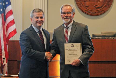 NC Attorney General Josh Stein gives mayor Patrick Taylor the 2019 Dogwood Award.