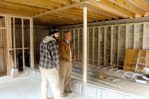 Ray Davis, of Northeast Georgia Heating and Air takes measurements of the potential retail space in a building being renovated on Fifth Street in downtown highlands.
