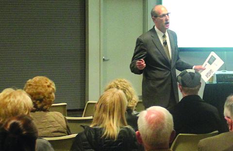 Gibbins Advisors Managing Director Tom Urban speaks to a crowd during a public forum in Highlands.