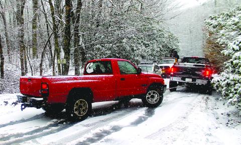 About a dozen vehicles were stranded on NC 106 between Bartram Way and Turtle Pond Road as snow fell on Highlands Friday morning.