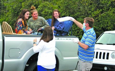 Highlands seniors Kedra McCall, Jeslyn Head and Ryan Talbert receive their senior academic awards and yearbooks outside the school on Tuesday afternoon.
