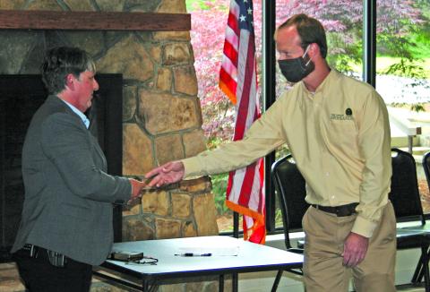 Highlands Police Chief Andrea Holland is presented with her new badge by town manager Josh Ward following a swearing-in ceremony on Thursday.