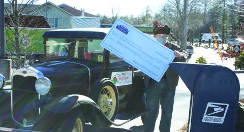 Highlands Motoring Festival organizer Steve Mehder did his best to fit a giant $15,000 check for three nonprofits into the mailbox.