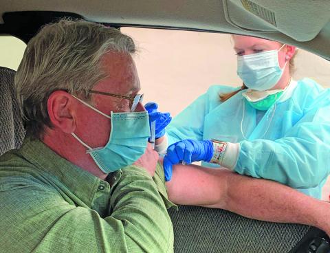 Dr. Donald Dewhurst received his COVID-19 vaccine from nurse Ruthie Capaforte at Macon County Public Health on Dec. 31.